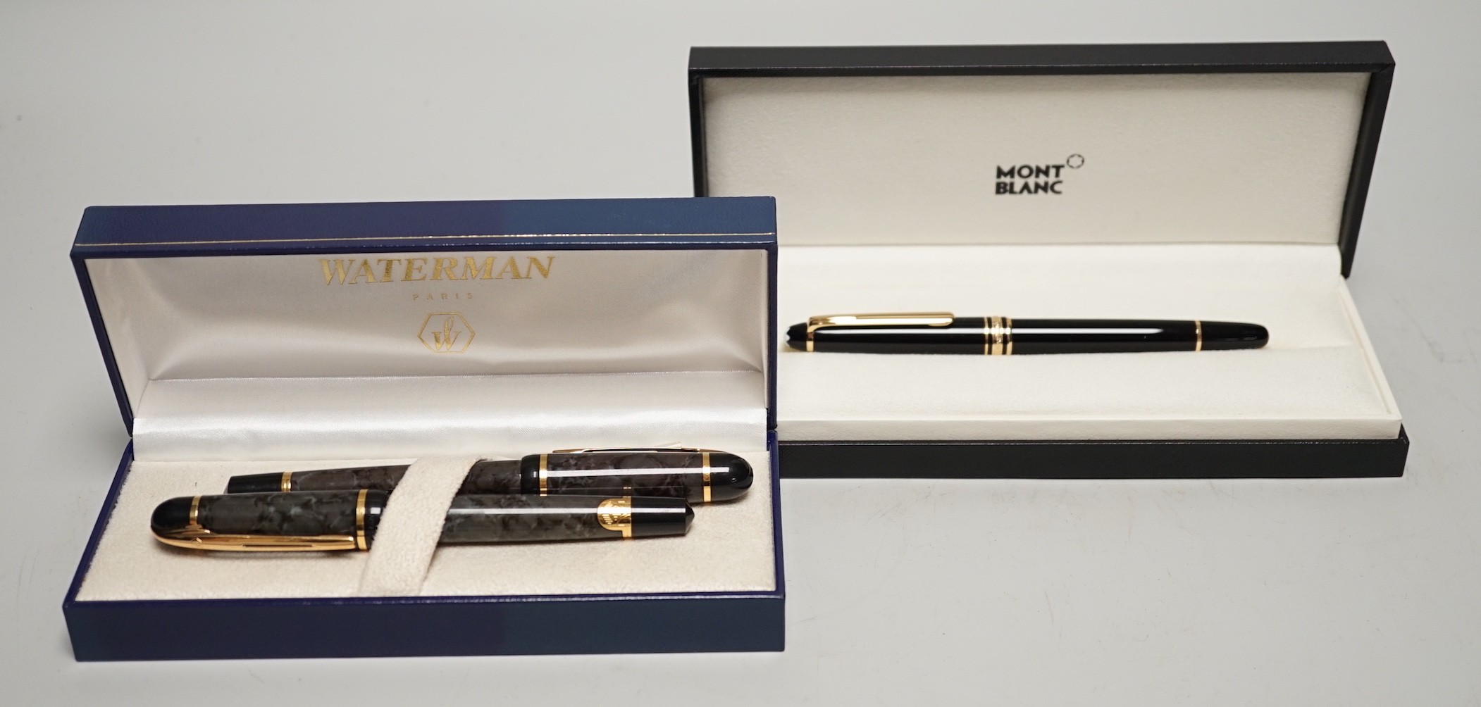 A Watermans marbled fountain pen and ballpoint pen ensuite, cased and a Montblanc ballpoint pen, cased